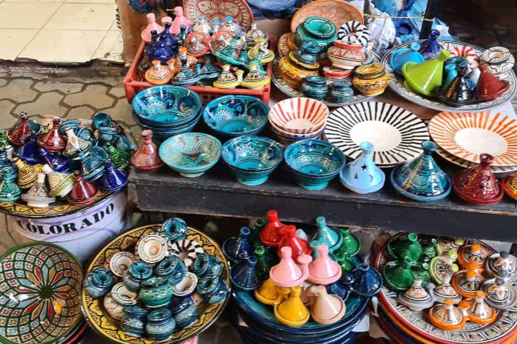 Colourful painted pots, dishes and plates on a market stall. Typical things to buy in Morocco.