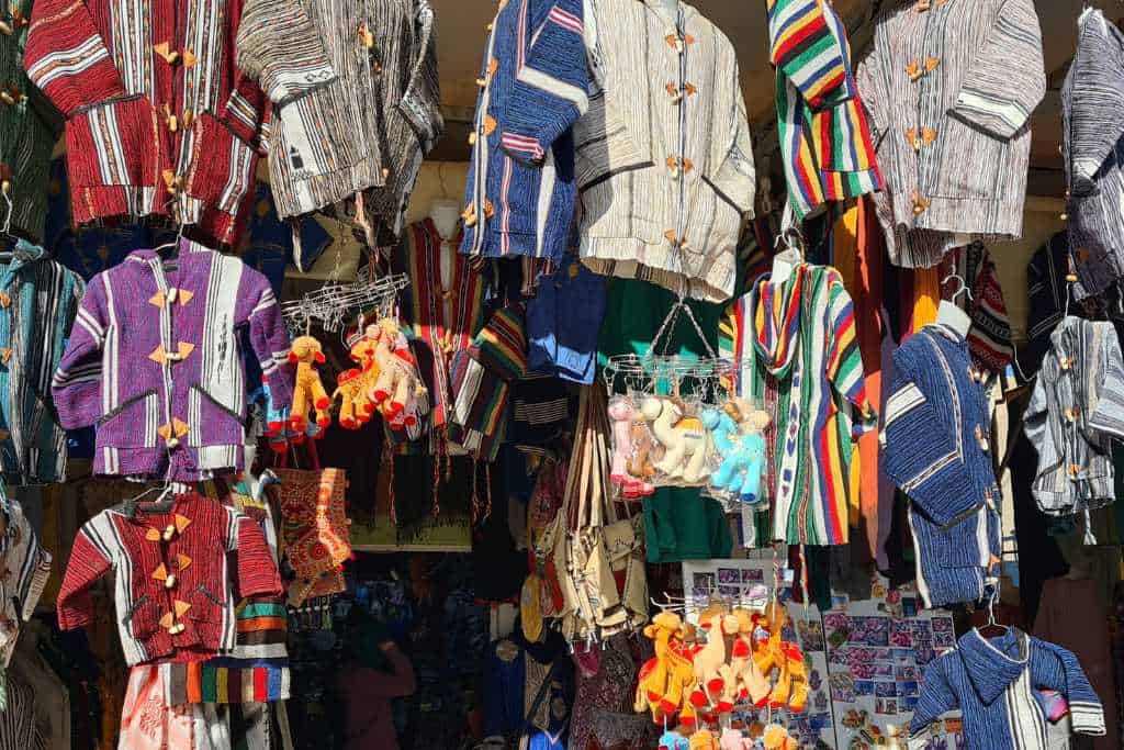 A street stall selling colourful clothes.