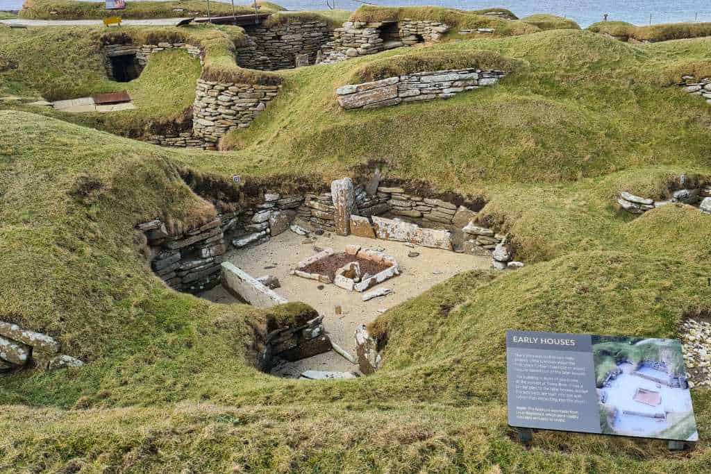 Grassy dune landscape at a beach with  exposed ancient ruins. Scara Brae is a popular attraction on Orkney. 