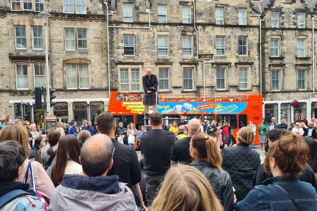 Street performers entertaining crowds in Edinburgh city.